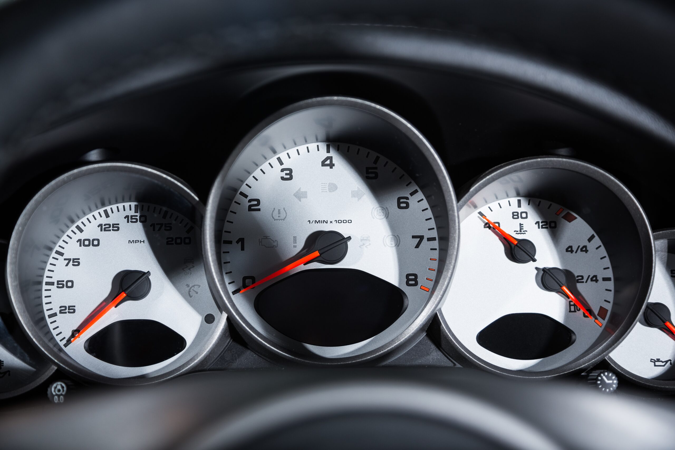 Speedometer and dashboard gauges of a modern luxury car, illustrating vehicle performance metrics relevant to car insurance savings based on mileage.